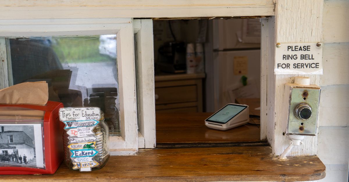 A quaint service window with a tip jar for education and a bell for service.